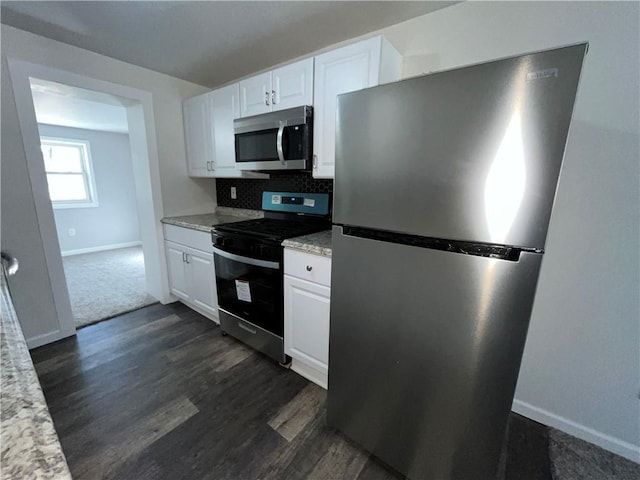 kitchen with white cabinets, baseboards, dark wood-style flooring, and stainless steel appliances