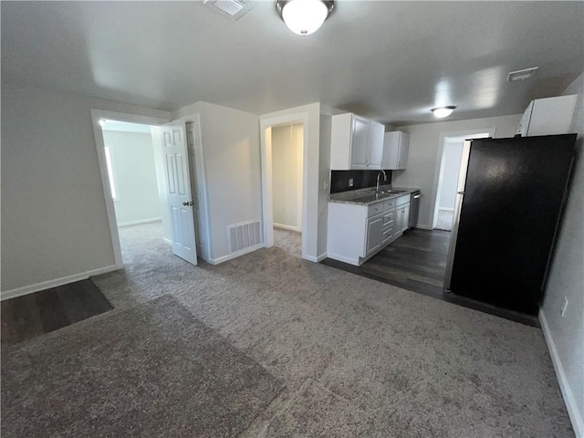 kitchen featuring baseboards, visible vents, a sink, appliances with stainless steel finishes, and white cabinetry