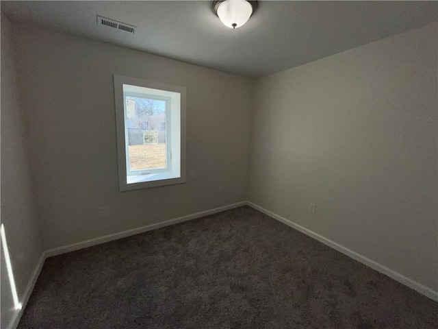 carpeted spare room featuring visible vents and baseboards