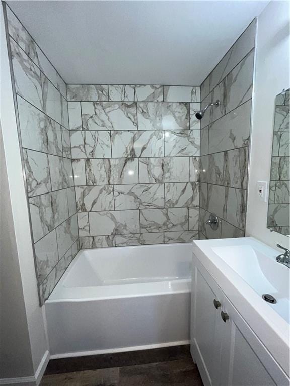 bathroom featuring baseboards, shower / washtub combination, wood finished floors, and vanity