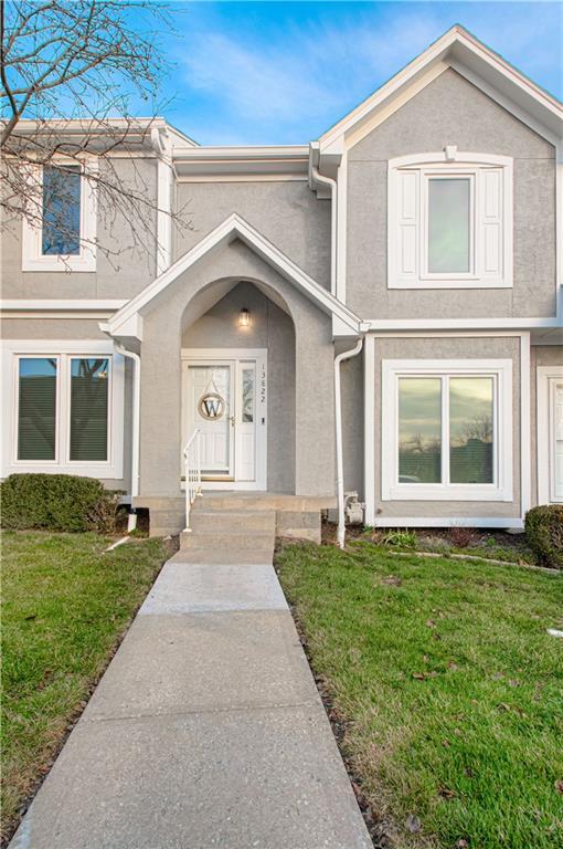 view of front facade with a front yard and stucco siding