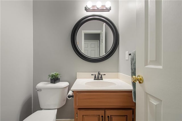 half bathroom with vanity and toilet