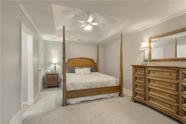 carpeted bedroom featuring a raised ceiling, a ceiling fan, a textured ceiling, crown molding, and baseboards