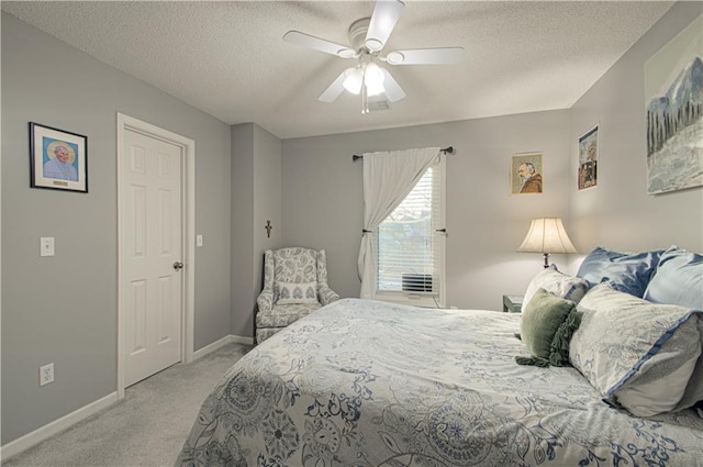 carpeted bedroom with a ceiling fan, baseboards, and a textured ceiling