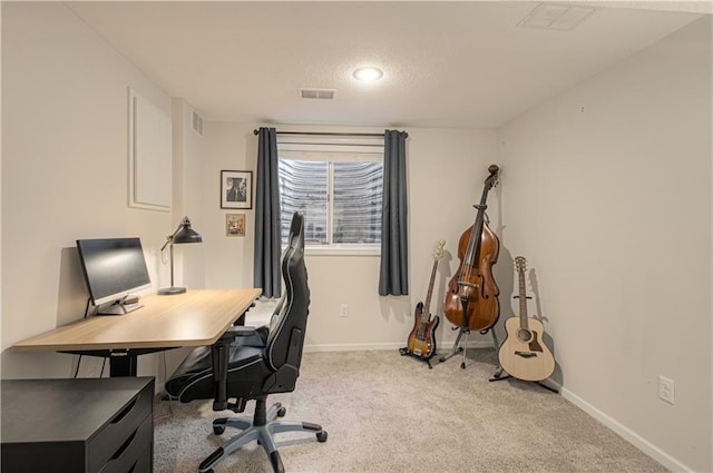 carpeted home office with visible vents, a textured ceiling, and baseboards