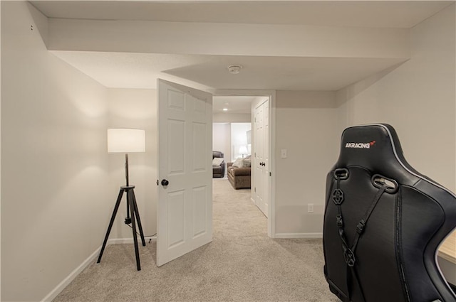 workout room featuring baseboards and light carpet