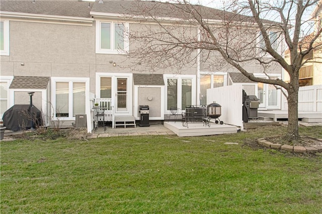 back of house featuring a shingled roof, a yard, fence, and stucco siding