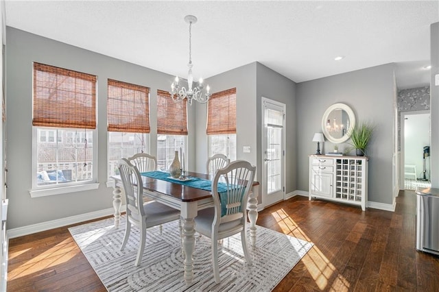 dining room featuring hardwood / wood-style floors, a textured ceiling, baseboards, and a chandelier