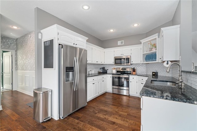 kitchen with visible vents, a sink, wainscoting, appliances with stainless steel finishes, and dark wood-style flooring