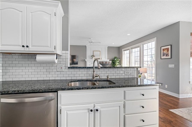 kitchen with a sink, stainless steel dishwasher, a peninsula, decorative backsplash, and dark wood-style flooring