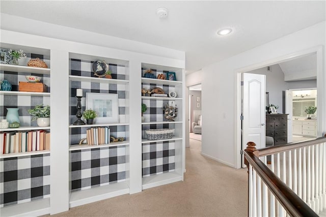 corridor with built in features, carpet, and baseboards