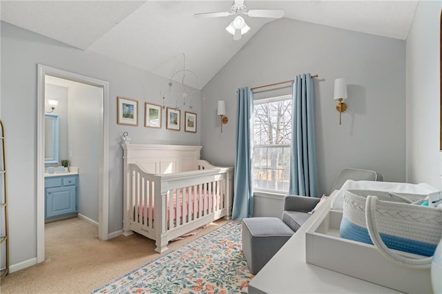 bedroom featuring baseboards, lofted ceiling, ceiling fan, a crib, and light colored carpet