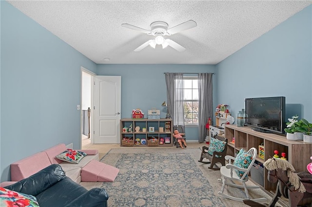 rec room featuring a ceiling fan, baseboards, carpet floors, and a textured ceiling