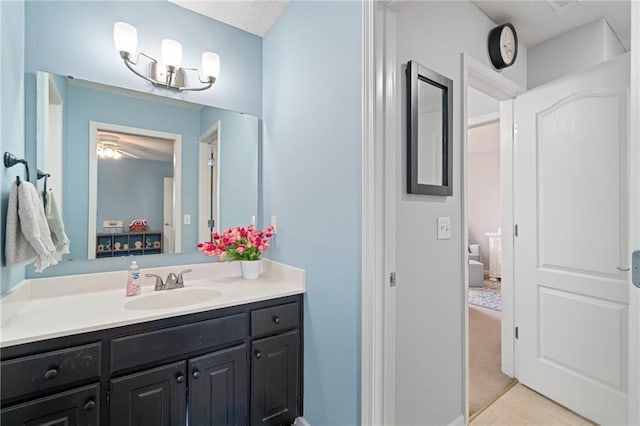 bathroom with a ceiling fan, vanity, and tile patterned flooring