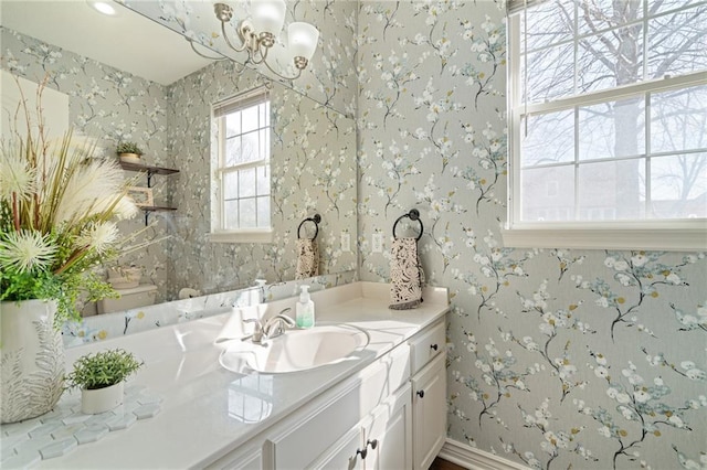 bathroom featuring wallpapered walls, vanity, and baseboards