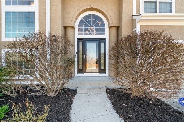 view of exterior entry featuring stucco siding