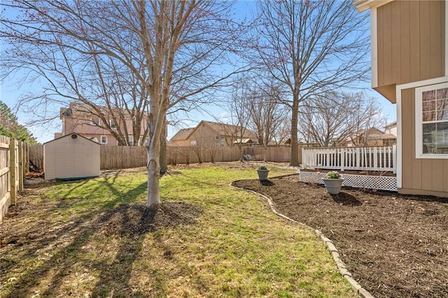 view of yard with a deck, an outdoor structure, a storage unit, and a fenced backyard