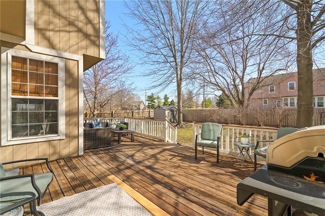 wooden terrace featuring a fenced backyard, a storage unit, and an outdoor structure