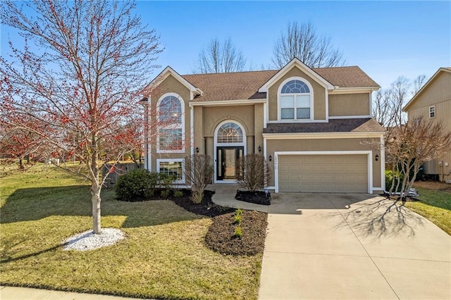 traditional home with a front lawn, concrete driveway, roof with shingles, stucco siding, and an attached garage