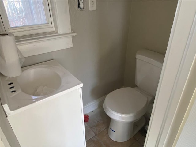 bathroom featuring baseboards, toilet, vanity, and tile patterned flooring