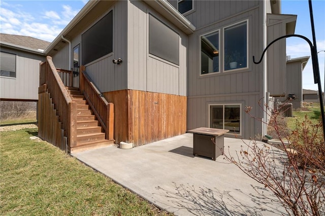 view of property exterior with a patio area, stairway, and a lawn