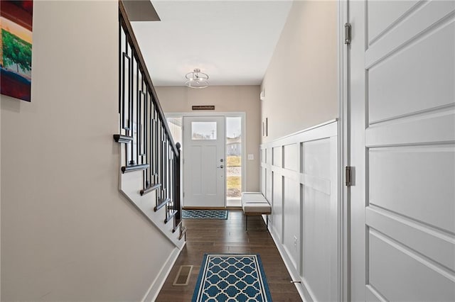 foyer featuring dark wood-type flooring, visible vents, baseboards, and stairway