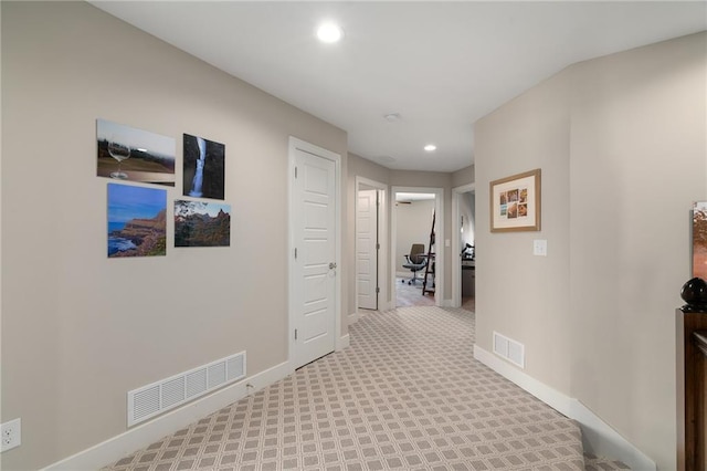 corridor featuring recessed lighting, visible vents, baseboards, and light colored carpet