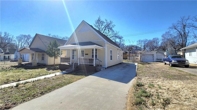 view of front of property featuring a porch, driveway, and an outdoor structure