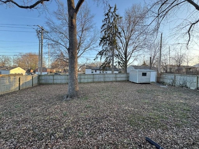 view of yard with a storage unit, a fenced backyard, and an outdoor structure