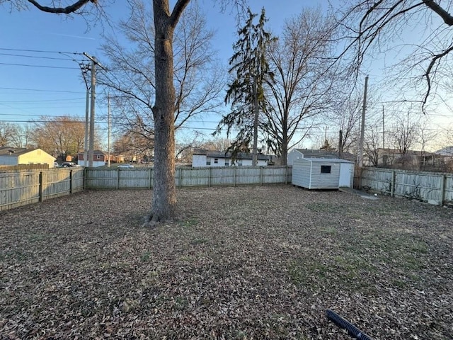 view of yard featuring an outbuilding, a fenced backyard, and a shed