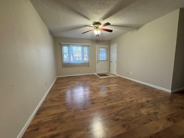 spare room featuring ceiling fan, baseboards, and wood finished floors