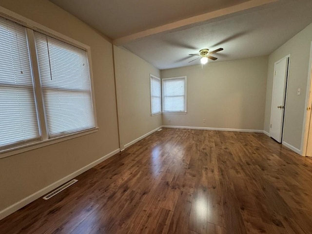 empty room featuring ceiling fan, visible vents, baseboards, and wood finished floors