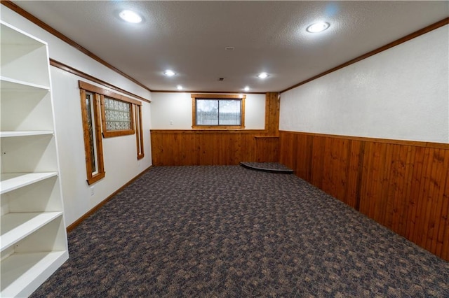 unfurnished room with crown molding, carpet, wood walls, wainscoting, and recessed lighting