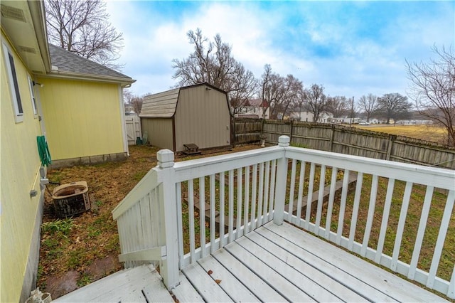 deck with an outdoor structure, central air condition unit, a storage unit, and a fenced backyard