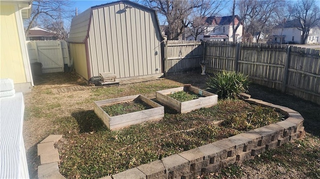 view of yard with a storage shed, a vegetable garden, a fenced backyard, and an outbuilding