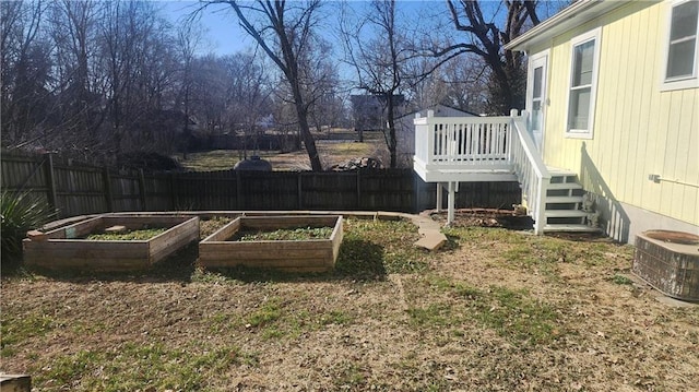 view of yard with cooling unit, a wooden deck, a vegetable garden, and fence