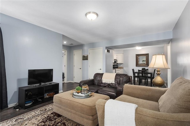 living room with dark wood-type flooring and baseboards