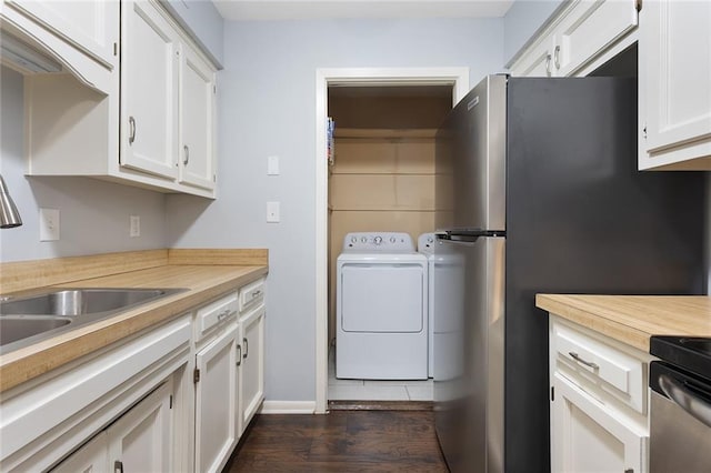 washroom with a sink, dark wood-style flooring, washing machine and dryer, and laundry area