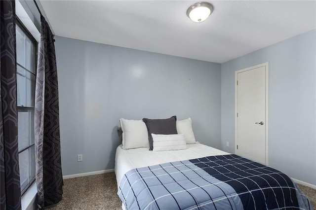 bedroom with baseboards and carpet