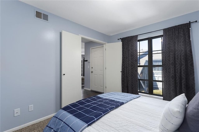 carpeted bedroom featuring visible vents and baseboards