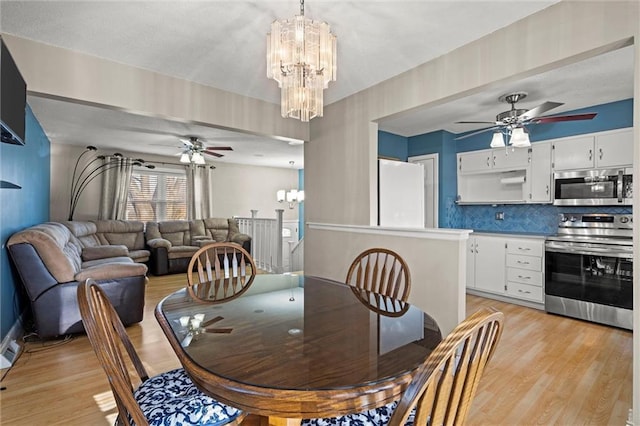 dining area featuring light wood-style floors and ceiling fan with notable chandelier