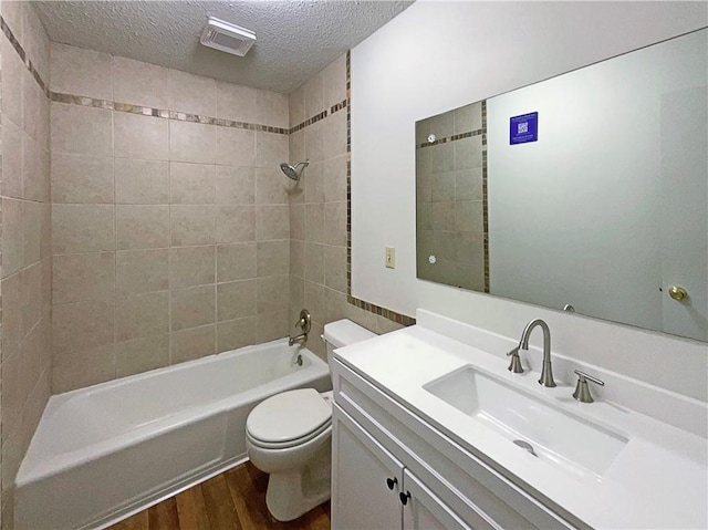 bathroom featuring visible vents, toilet, a textured ceiling, wood finished floors, and shower / bathtub combination