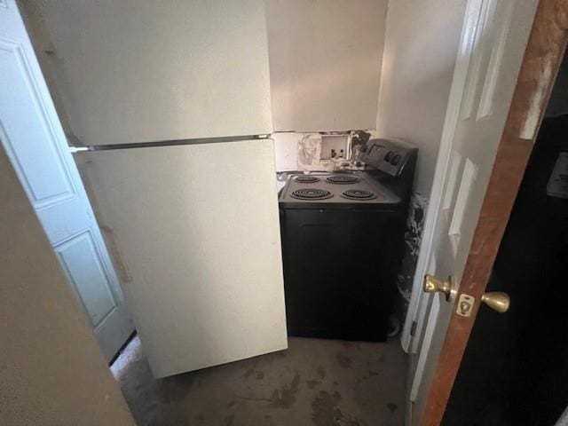 kitchen with black range with electric stovetop and freestanding refrigerator