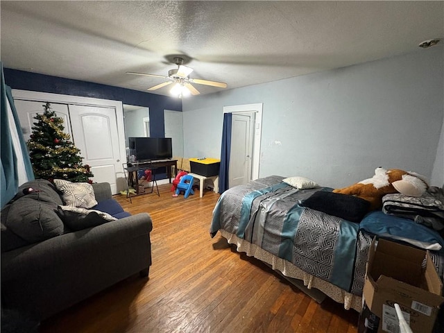 bedroom featuring a textured ceiling, ceiling fan, and wood finished floors