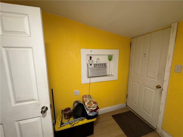 interior space with wood finished floors, baseboards, and vaulted ceiling