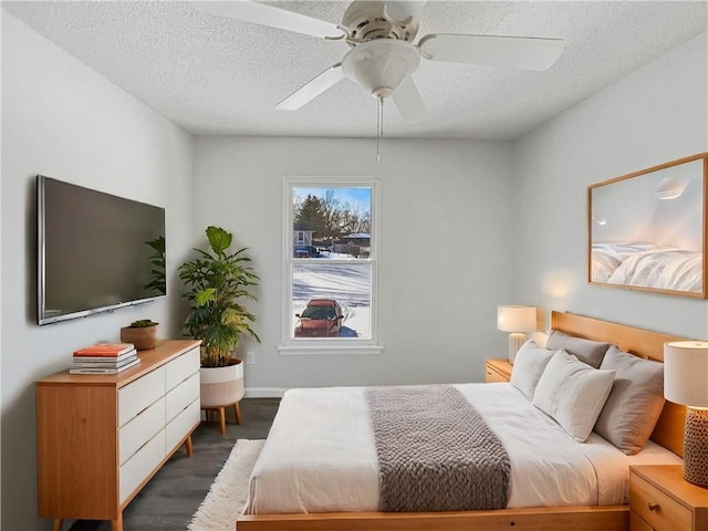 bedroom with ceiling fan, a textured ceiling, and wood finished floors