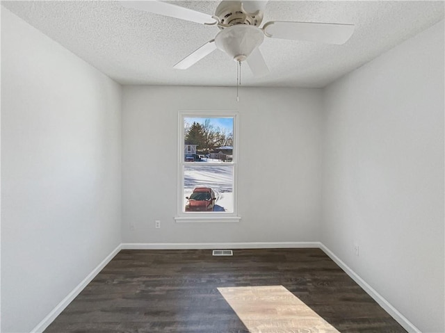 unfurnished room with ceiling fan, a textured ceiling, baseboards, and wood finished floors