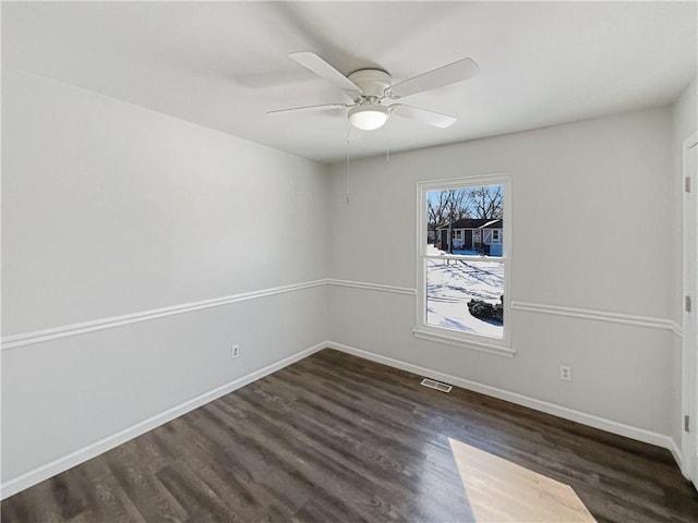 spare room featuring visible vents, baseboards, wood finished floors, and a ceiling fan