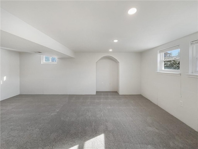 carpeted empty room featuring arched walkways, recessed lighting, and a healthy amount of sunlight