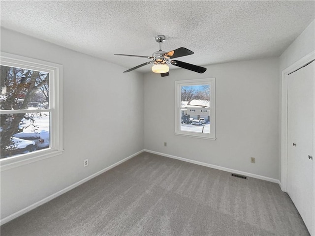 unfurnished bedroom featuring visible vents, baseboards, carpet flooring, a closet, and a textured ceiling